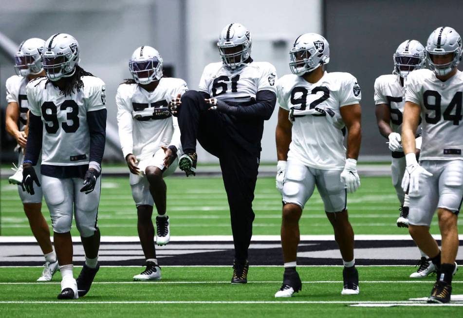 Raiders defensive tackle Gerald McCoy (61) warms up alongside teammates during training camp at ...