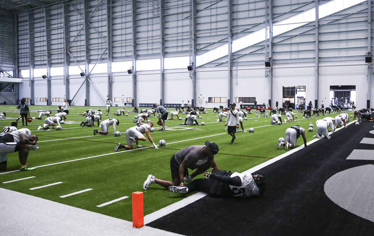 Raiders defensive tackle Gerald McCoy, lower center, stretches during training camp at Raiders ...
