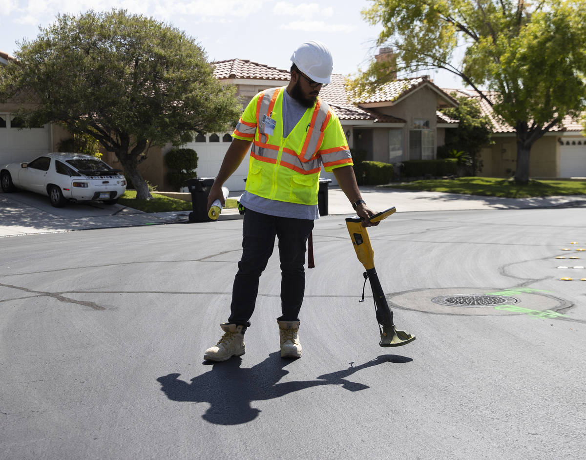 Jacob Olim, locate technician for Stake Center, uses a receiver to locate underground gas lines ...