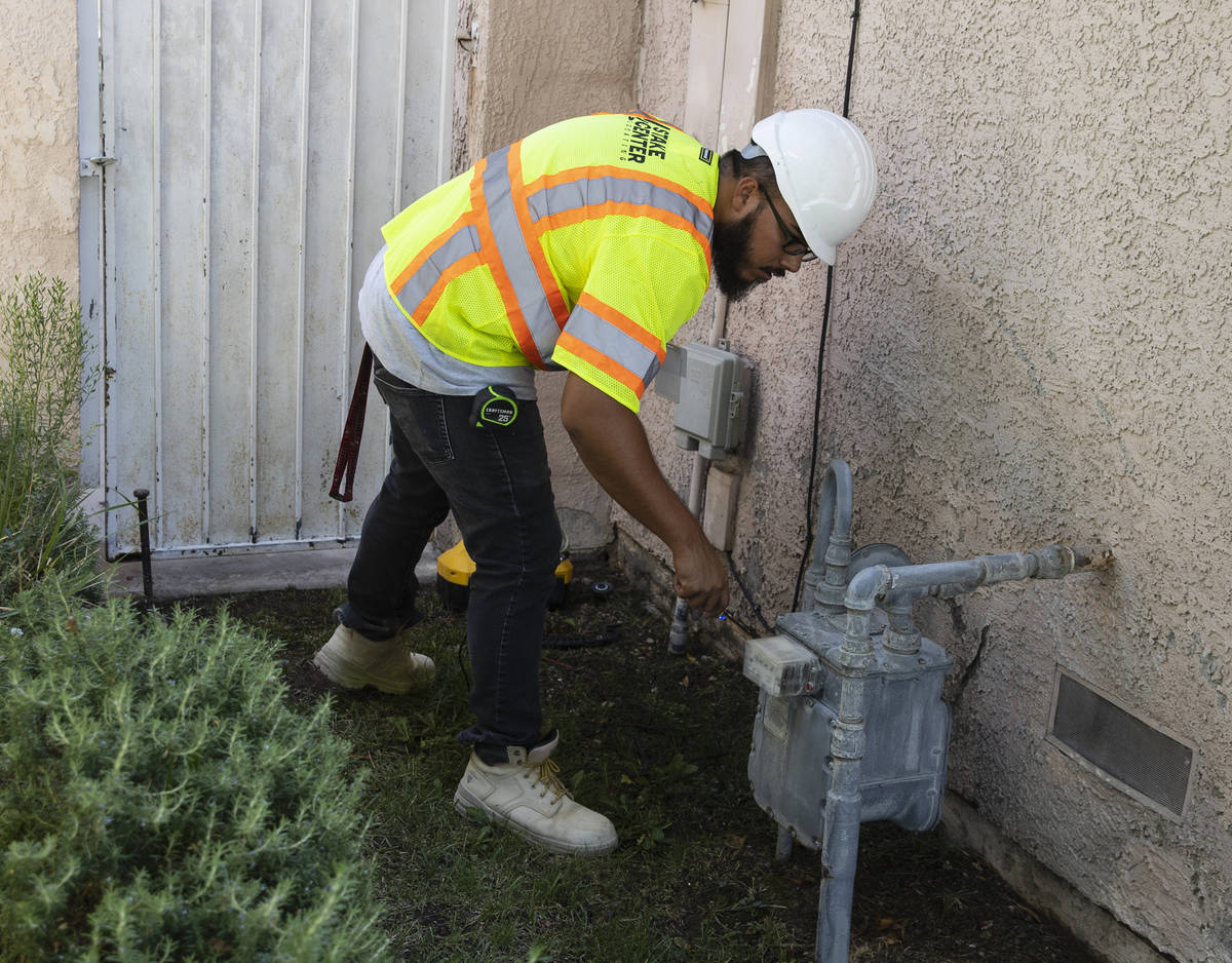 Jacob Olim, locate technician for Stake Center, attaches copper wire from a transmitter to the ...