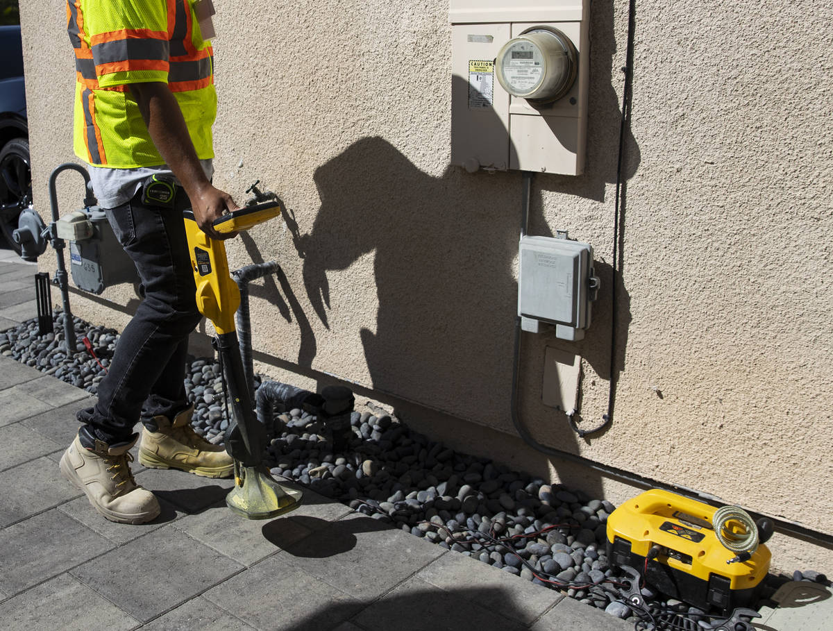 Jacob Olim, locate technician for Stake Center, uses a receiver to locate underground gas lines ...