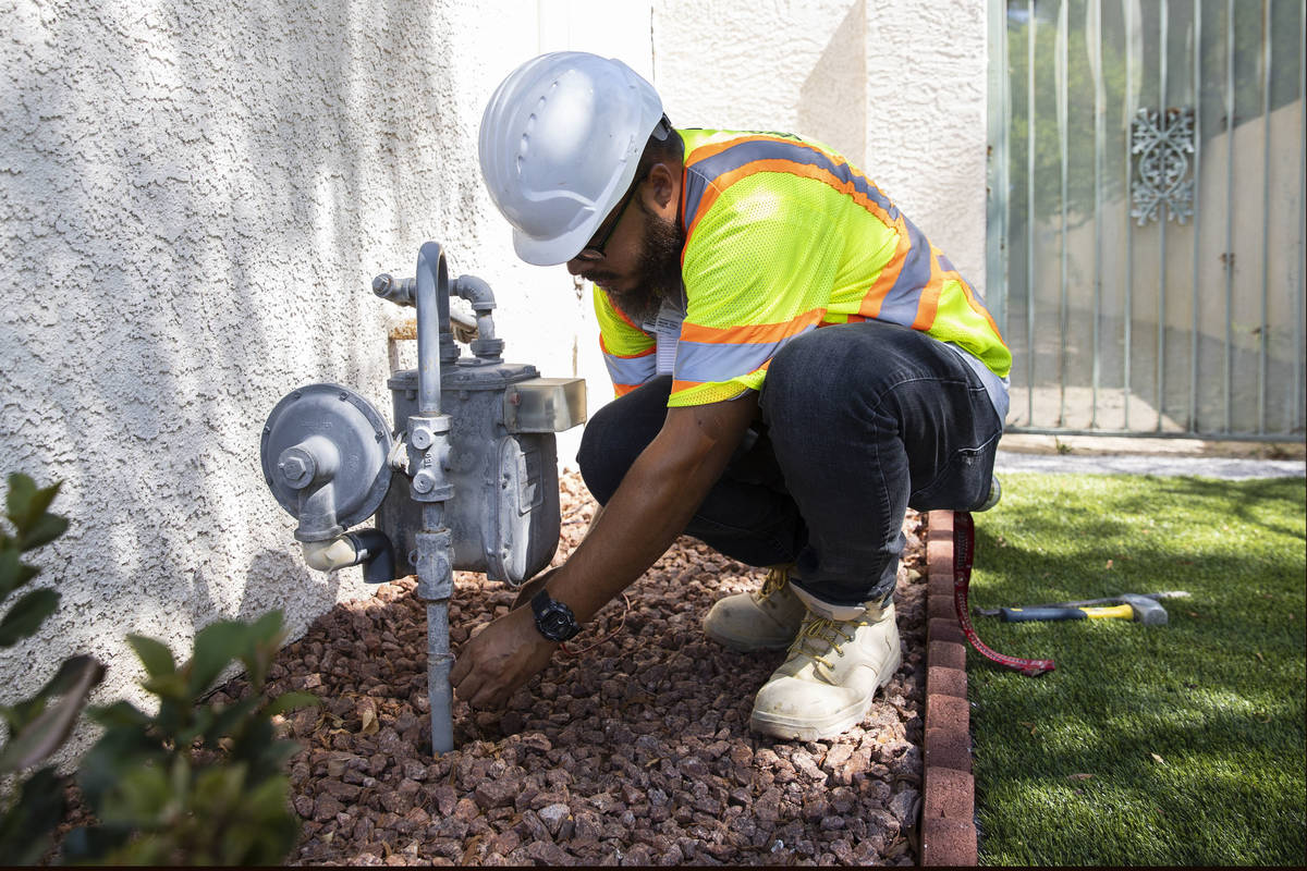 Jacob Olim, locate technician for Stake Center, attaches copper wire from a transmitter to the ...