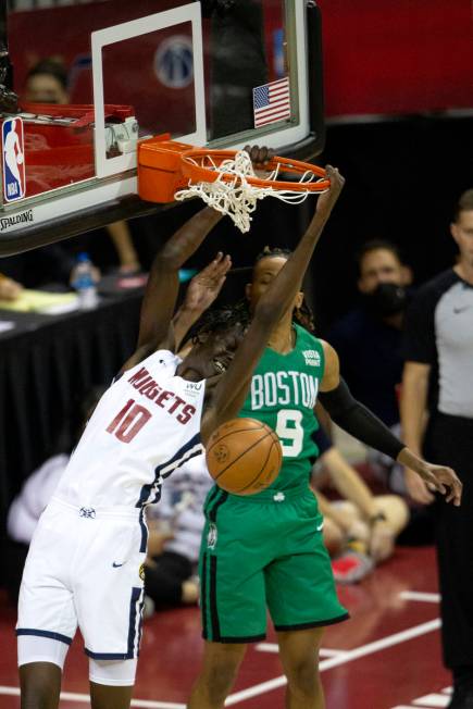 Denver Nuggets center Bol Bol (10) dunks as Boston Celtics guard Romeo Langford (10) jumps to b ...