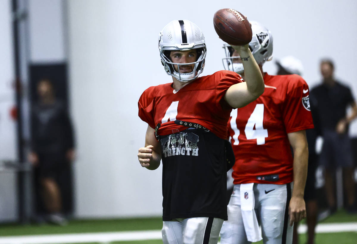 Raiders quarterback Derek Carr motions while holding a football during training camp at Raiders ...