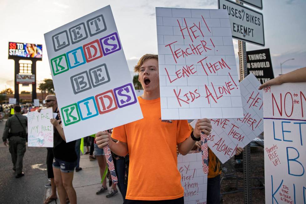Jacob Dennon holds a sign opposing the mask mandate for Clark County School District students o ...