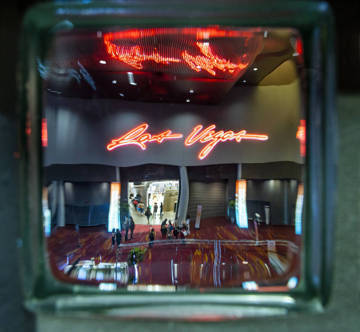 Attendees entering the central hall are seen through glass block during the MAGIC apparel show ...