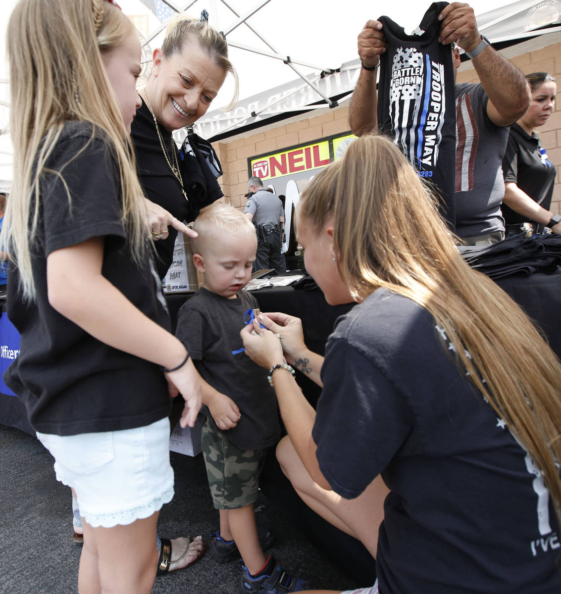 Porsche Sepanek of Las Vegas, right, pins a blue ribbon to the shirt of her son Cayman, 2, cent ...