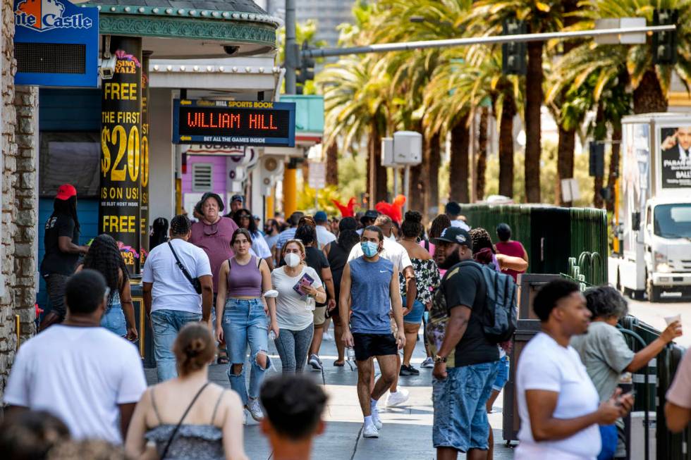 People walk along the Strip near The Venetian, most not wearing masks anymore on Friday, July 1 ...