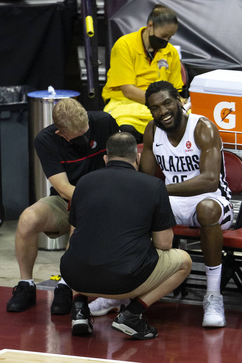 Portland Trail Blazers forward Kenneth Faried (50) is attended to by trainers after getting inj ...
