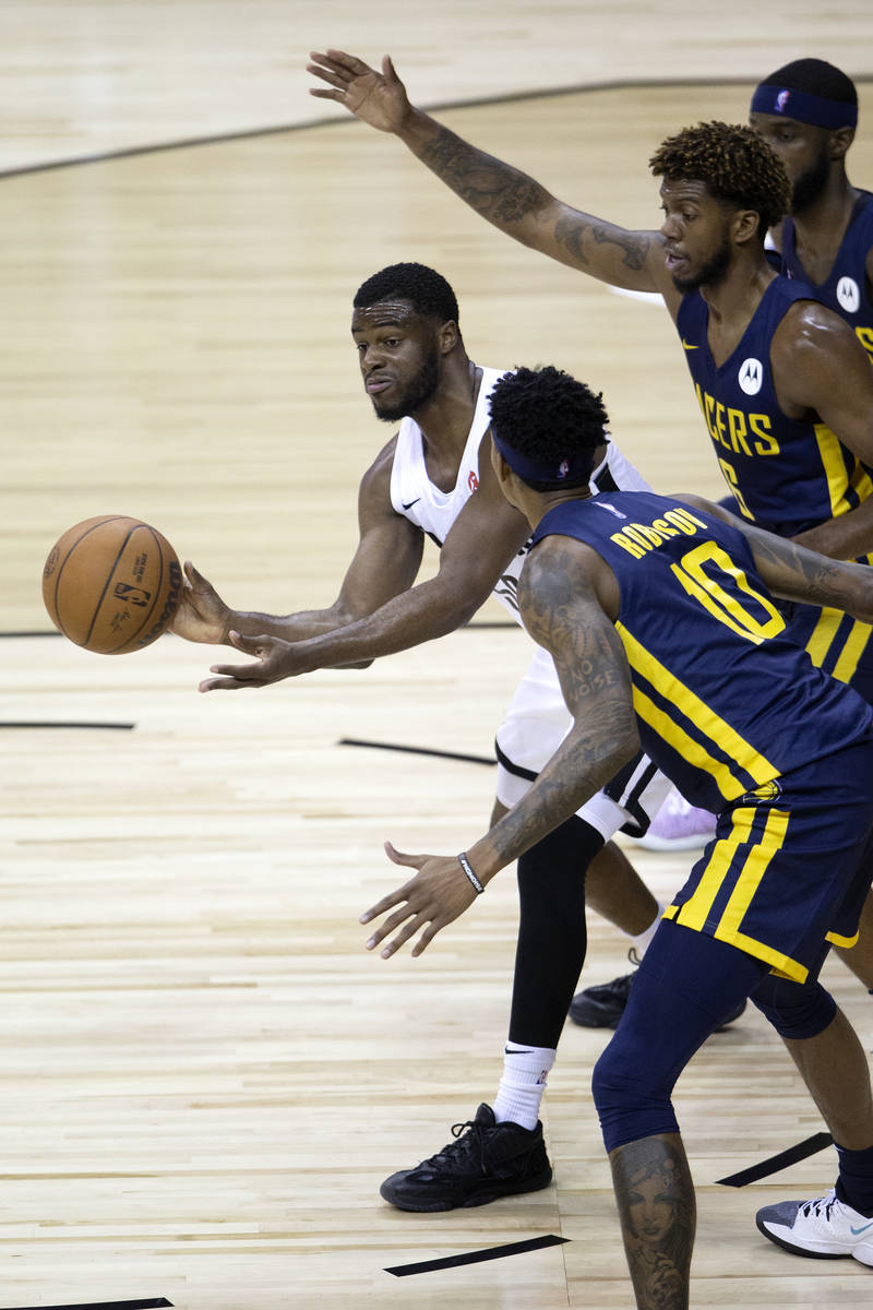 Portland Trail Blazers guard Emmanuel Mobiay (58) passes flanked by Indiana Pacers forward Devi ...