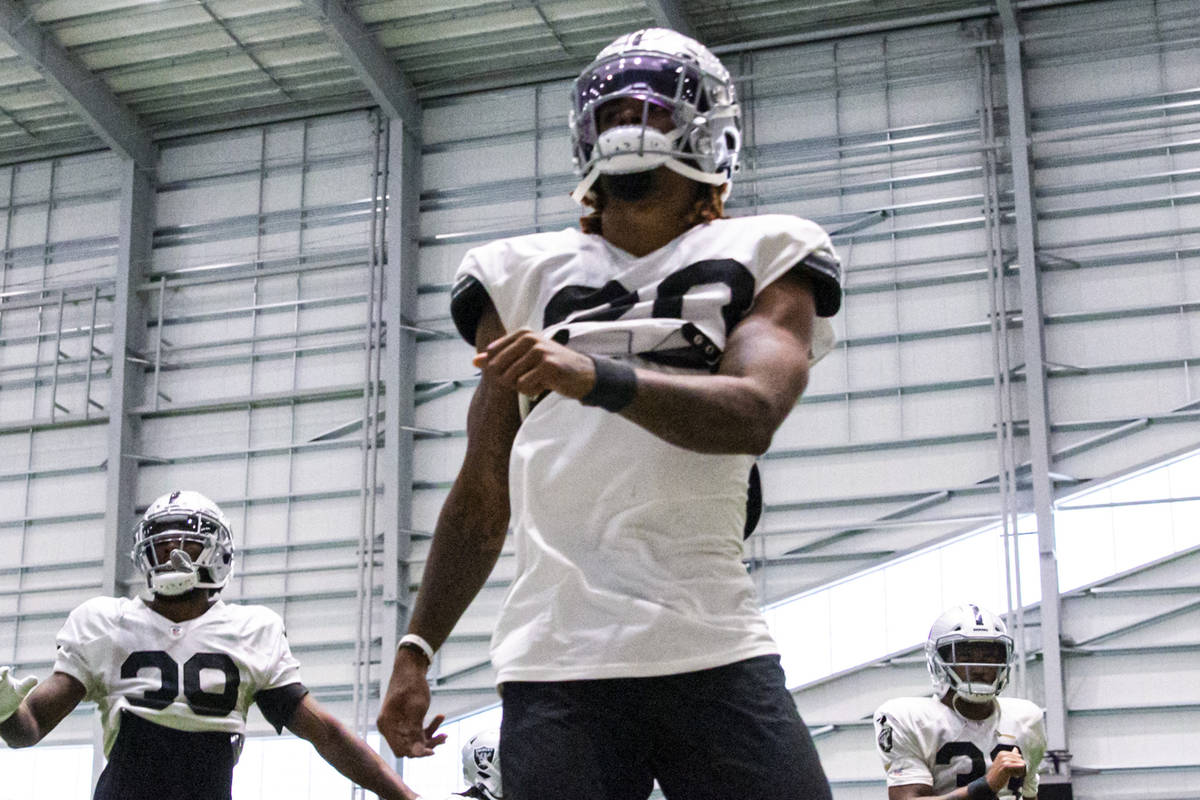 Raiders cornerback Damon Arnette, center, warms up with teammates during training camp at Raide ...