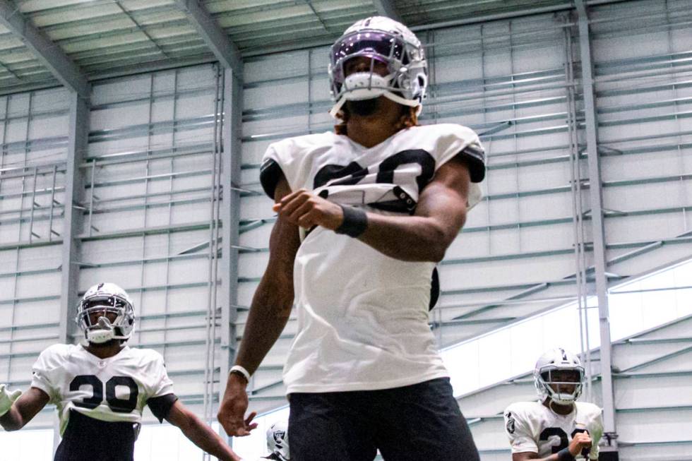 Raiders cornerback Damon Arnette, center, warms up with teammates during training camp at Raide ...