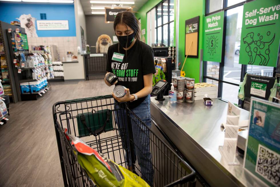 Team member Victoria Ornelas scans a customer's items at check out at Pet Supplies Plus, owned ...