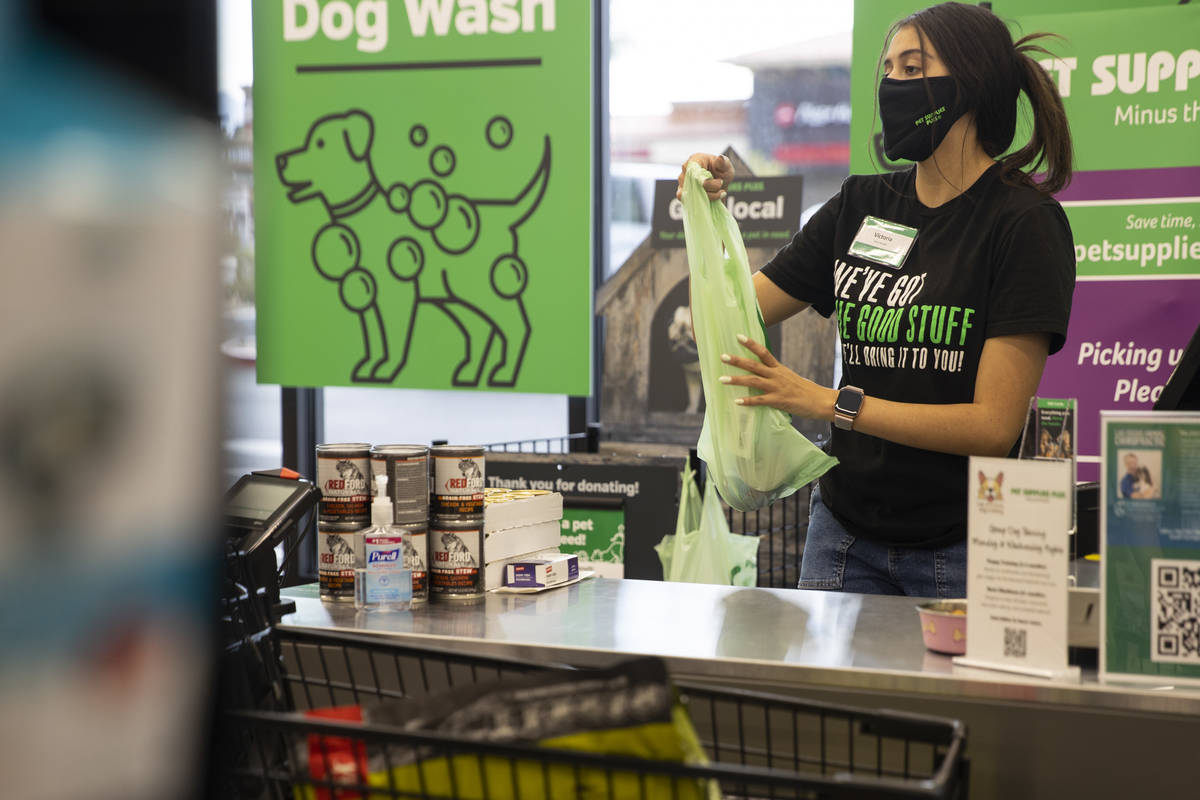 Team member Victoria Ornelas hands a customer their items at check out at Pet Supplies Plus, ow ...