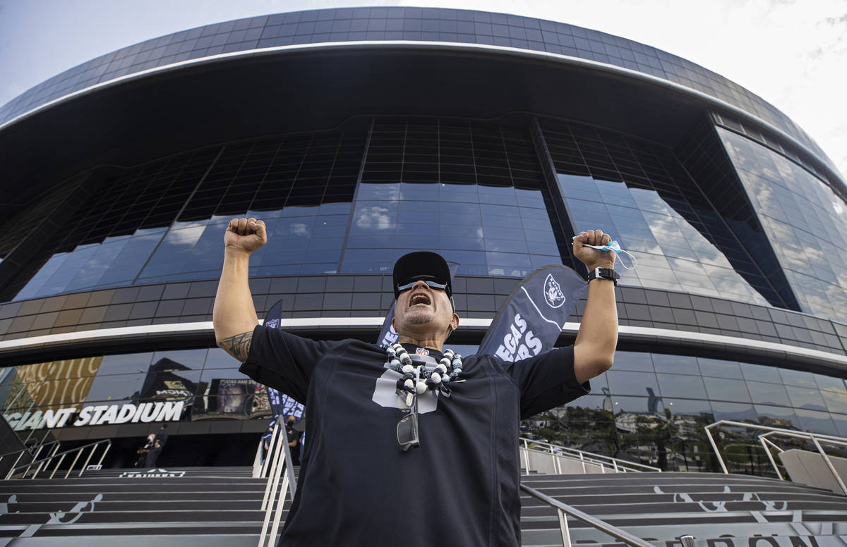 Raiders fan John Ioane celebrates outside Allegiant Stadium before the start of an NFL preseaso ...