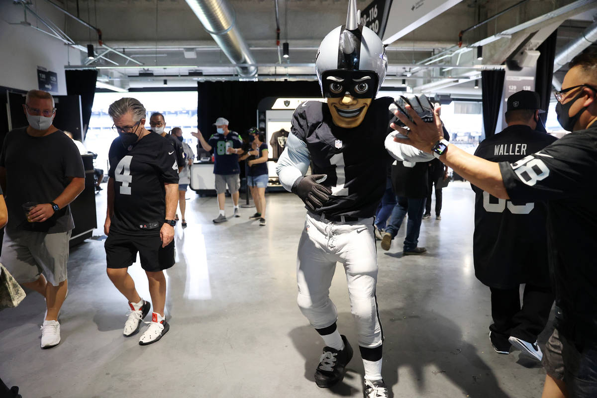 Raiders' NFL mascot Raider Rusher high fives fans while walking the concourse of Allegiant Stad ...