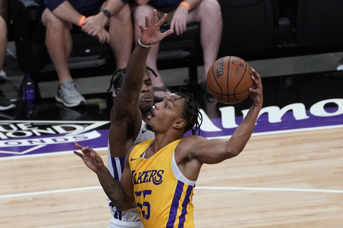 Sacramento Kings guard Davion Mitchell, left, tries to block the shot of Los Angeles Lakers gua ...