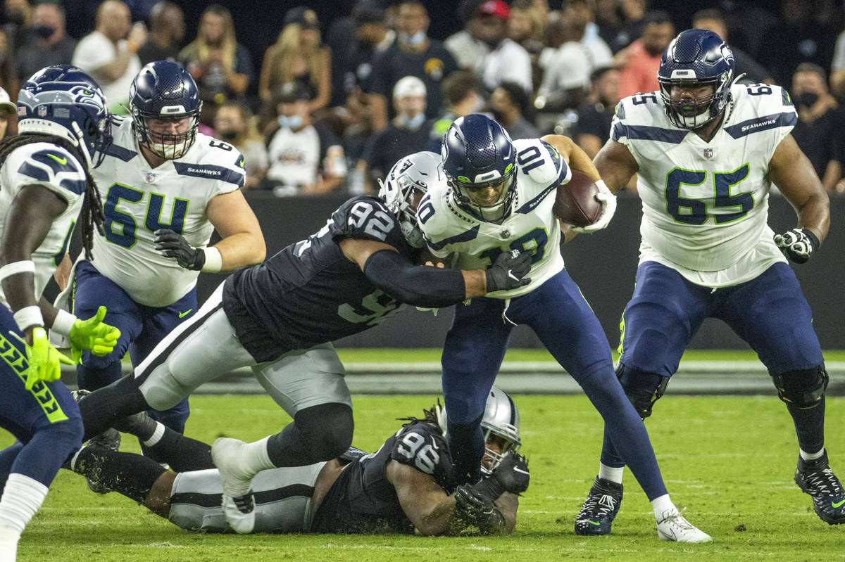Seattle Seahawks quarterback Alex McGough (10) is tackled by Raiders defensive end Solomon Thom ...