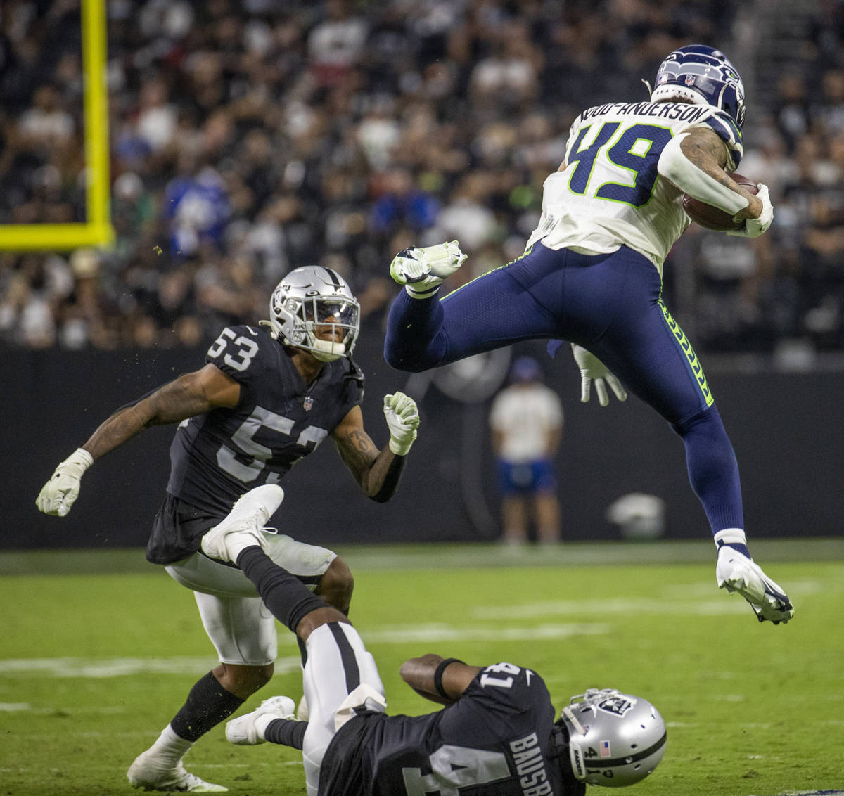 Seattle Seahawks tight end Dom Wood-Anderson (49) leaps over Raiders cornerback DeVante Bausby ...