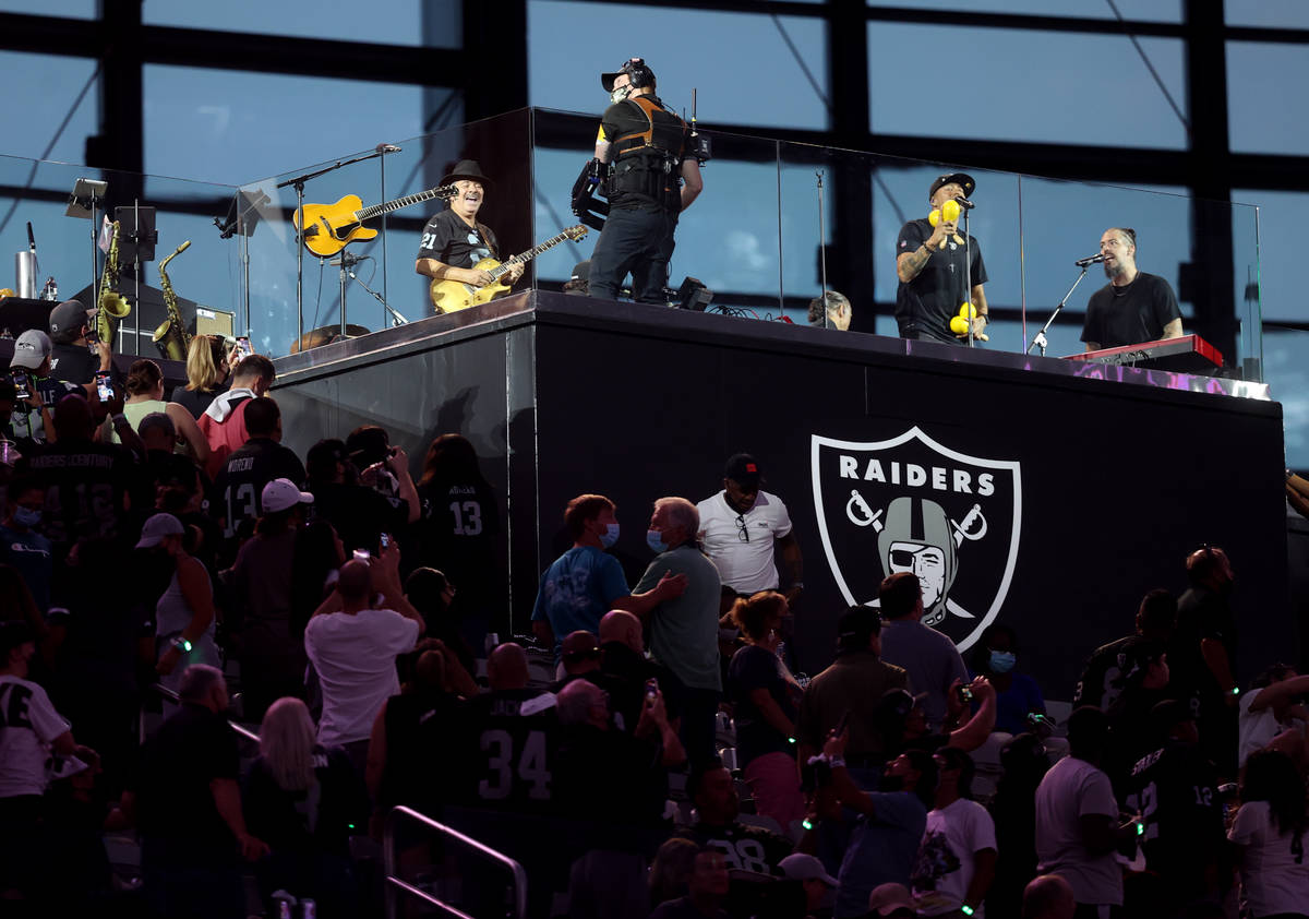 Carlos Santana, left, performs during halftime of the Raiders home opening preseason NFL footba ...