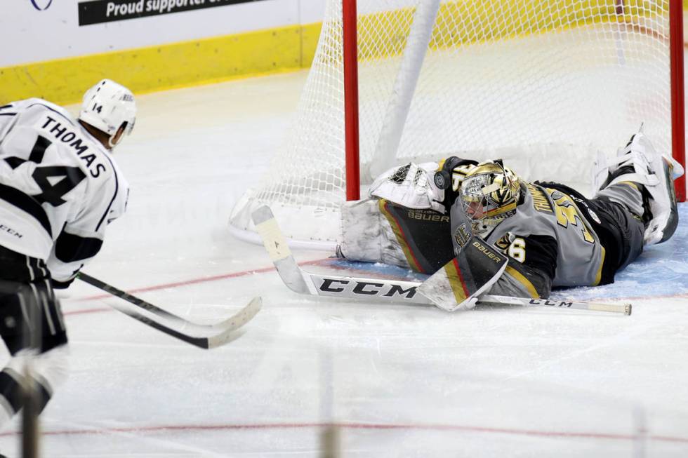 Henderson Silver Knights goaltender Logan Thompson(36) blocks a shot from Ontario Reign Akil Th ...