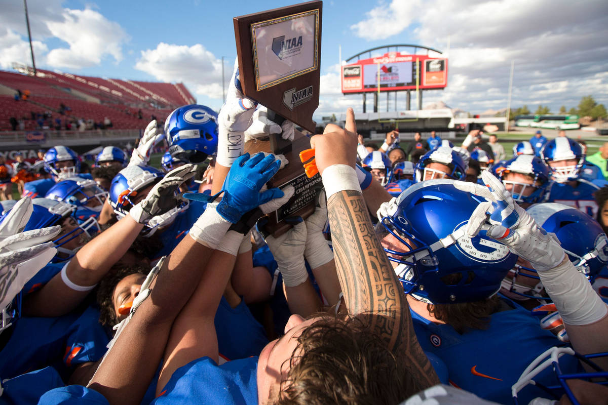 Bishop Gorman players celebrate with the trophy after defeating Reno's Bishop Manogue 69-26 in ...