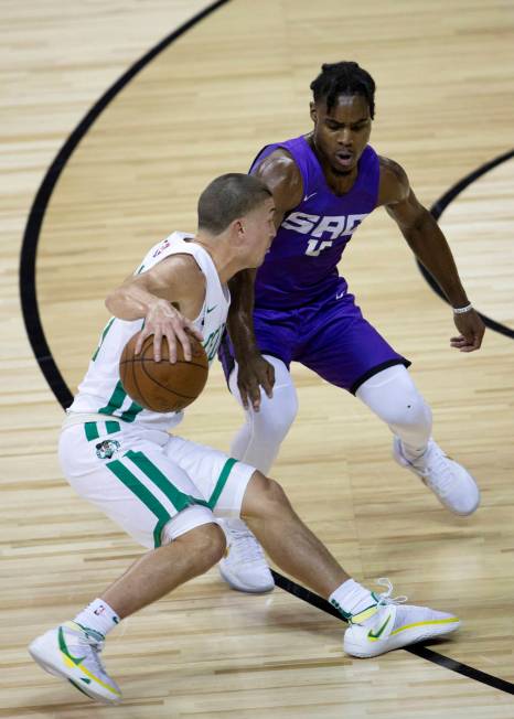 Boston Celtics guard Payton Pritchard (11) dribbles around Sacramento Kings guard Davion Mitche ...