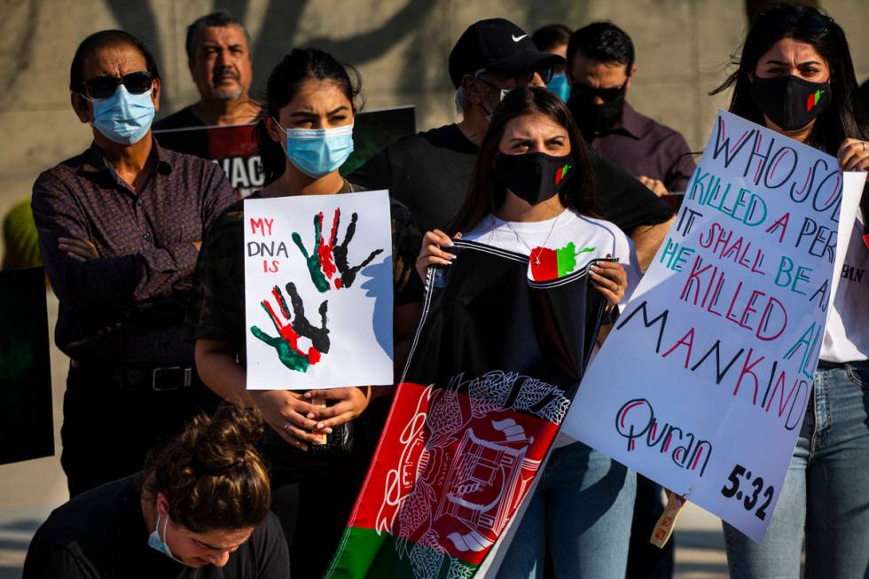 People hold up signs during a protest against the Taliban and in support of Afghanistan on Tues ...