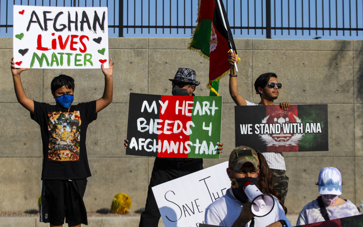 People hold up signs during a protest against the Taliban and in support of Afghanistan on Tues ...