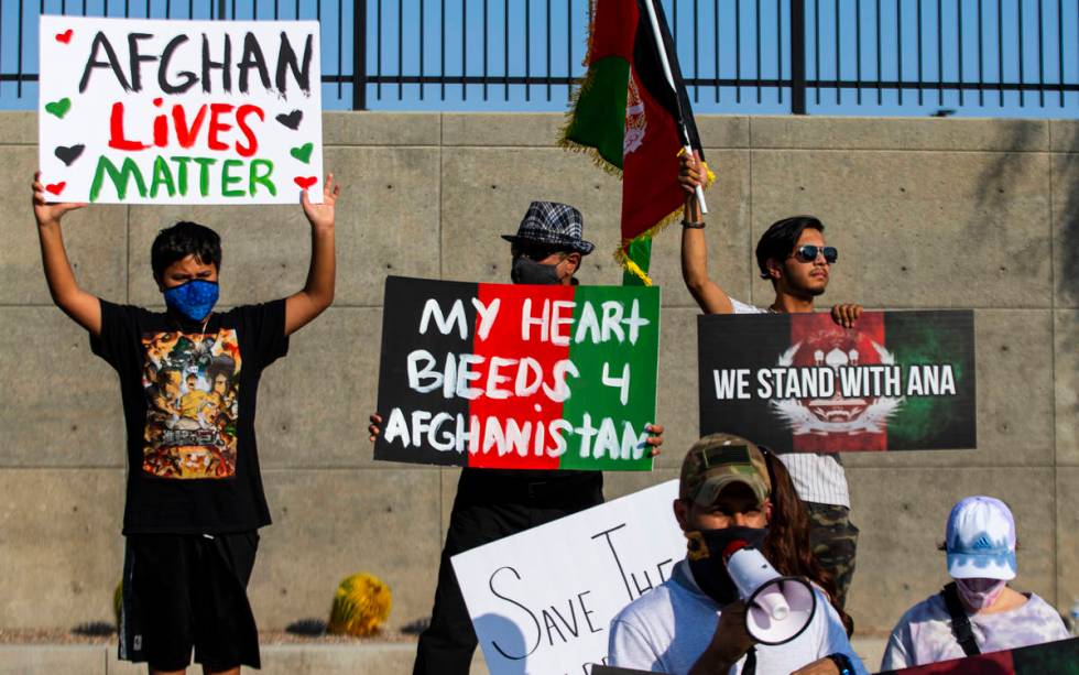 People hold up signs during a protest against the Taliban and in support of Afghanistan on Tues ...