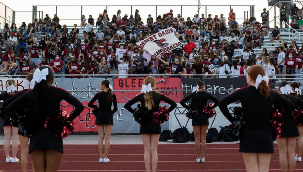 Cheerleaders stand at attention as Desert Oasis fans pack the bleachers during a high school fo ...