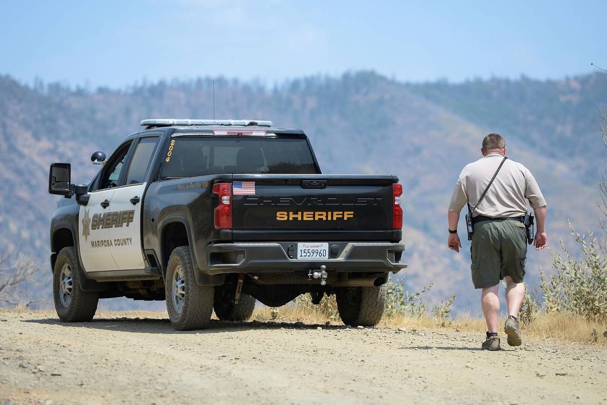 A Mariposa County deputy sheriff stands watch over a remote area northeast of the town of Marip ...