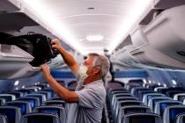 In this May 28, 2020, file photo, a passenger wears personal protective equipment on a Delta Ai ...