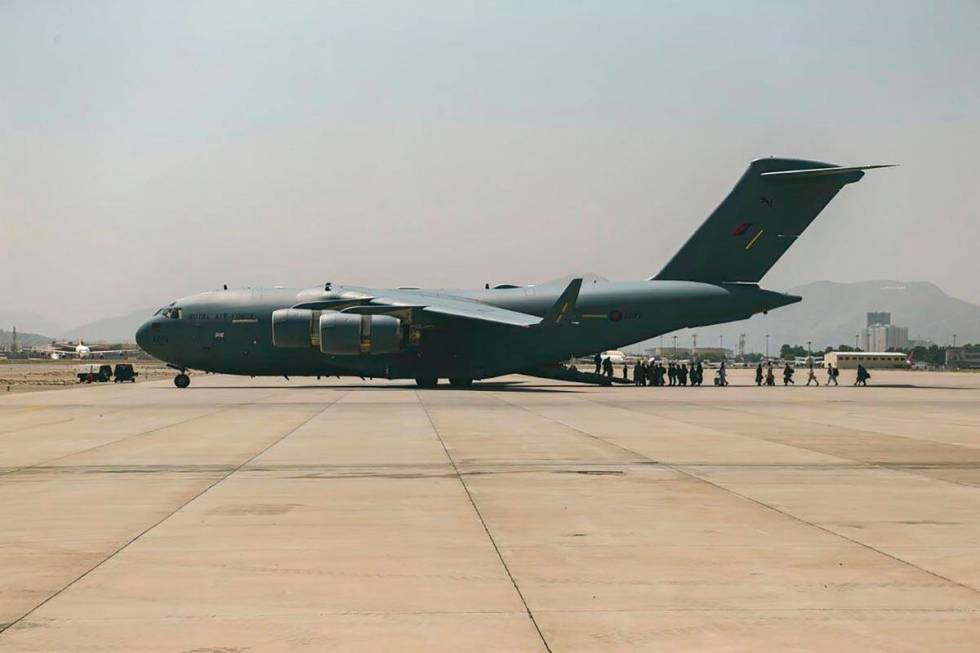 In this image provided by the U.S. Marine Corps, evacuees load on to a Boeing C-17 Globemaster ...