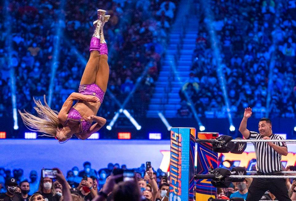 Charlotte Flair flies off the top ropes onto Nikki A.S.H. and Rhea Ripley below in the Raw Wome ...