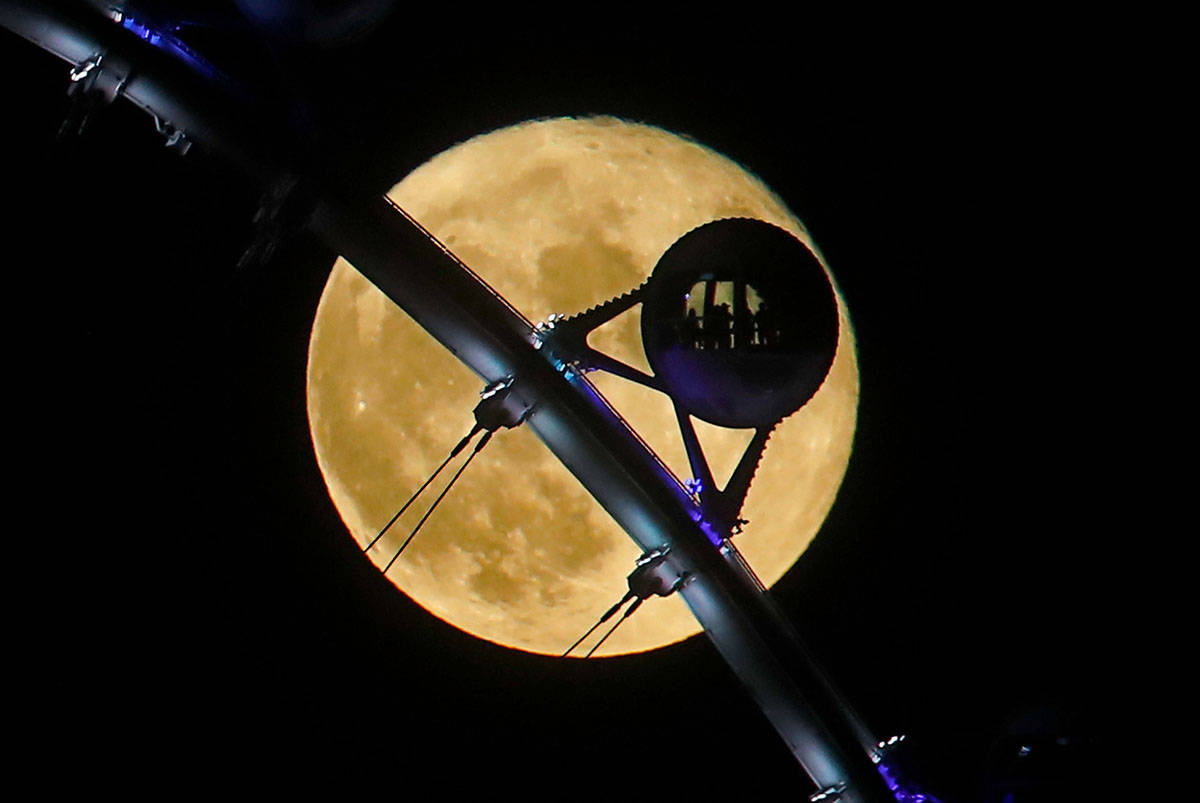 A full moon rises behind the High Roller observation wheel on the Strip in Las Vegas, Sunday, A ...