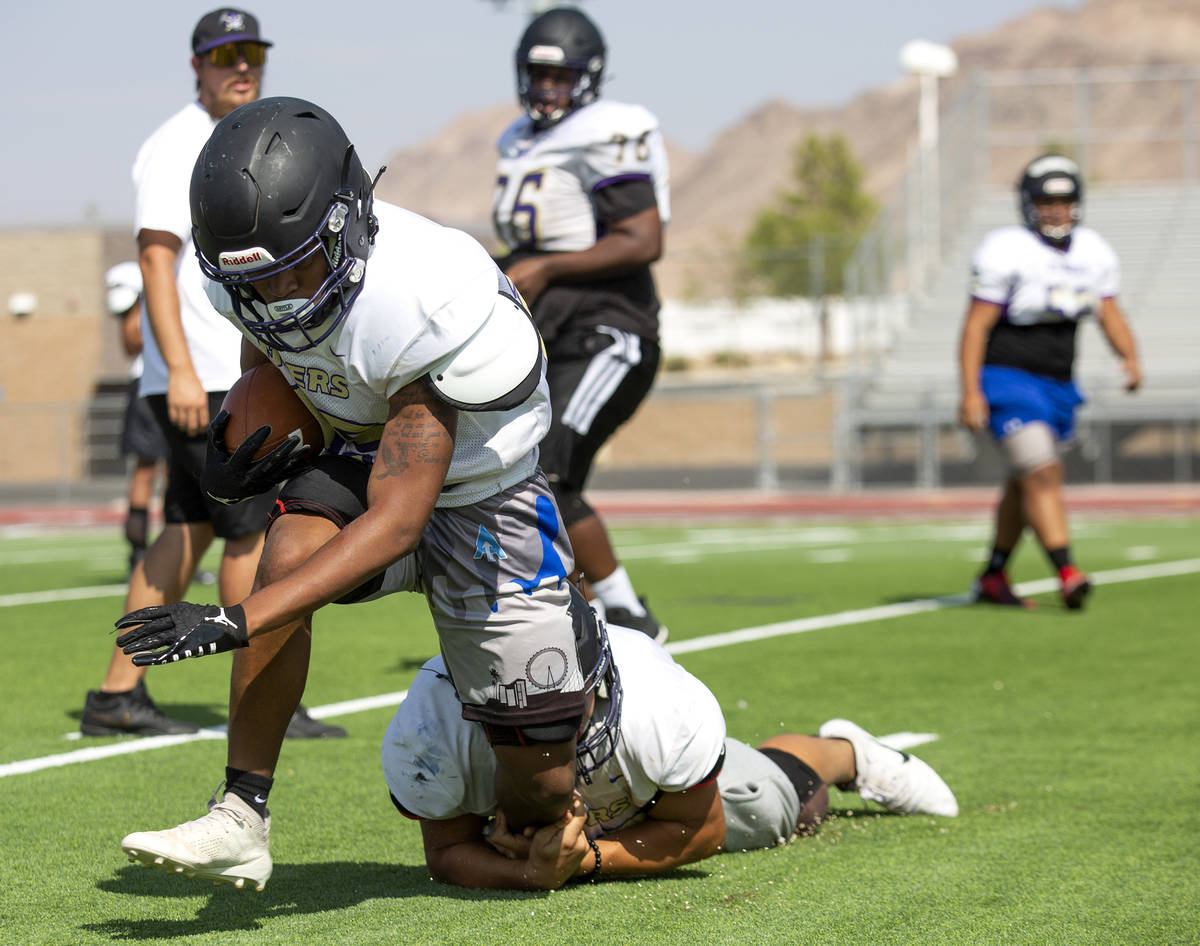 Senior Xzavier White is tackled by senior Jayce Gaines during varsity football practice at Sunr ...