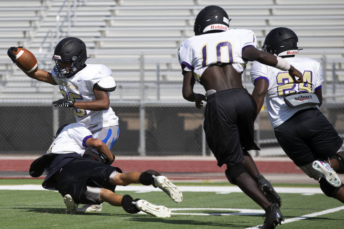 Senior Xzavier White is tackled by junior Austin Dillon during varsity football practice at Sun ...