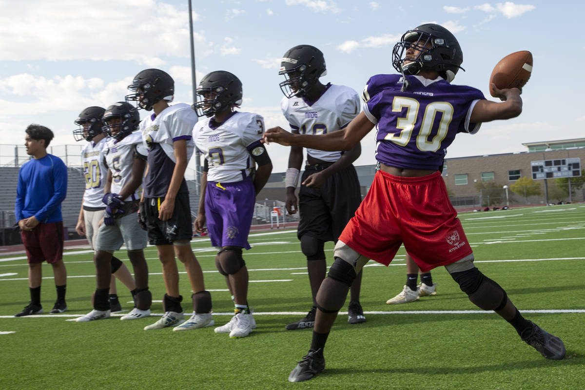 Freshman Deshawn Banks, right, participates in offensive drills during varsity football practic ...