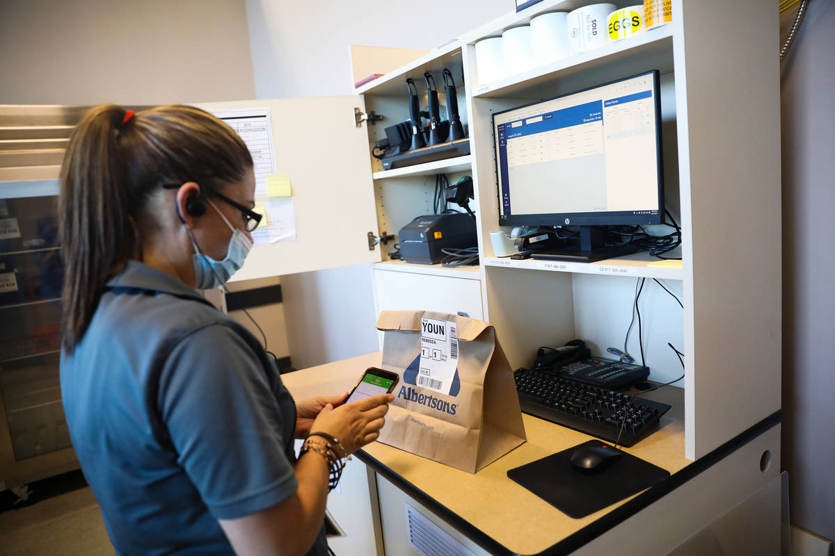 Tasha Tejada, lead for the Drive Up & Go section, demonstrates how an Instacart employee wo ...