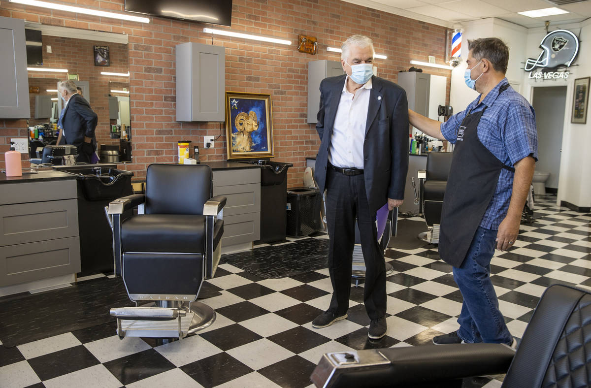 Gov. Steve Sisolak, left, gets a tour of Paul Madrid's new space at the Eastside Cutters Barber ...