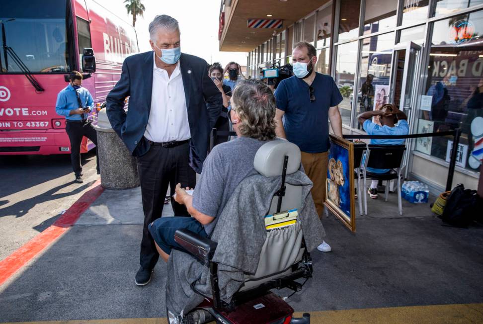 Gov. Steve Sisolak, left, talks with passer-by Todd Schwarting following a tour at the Eastside ...