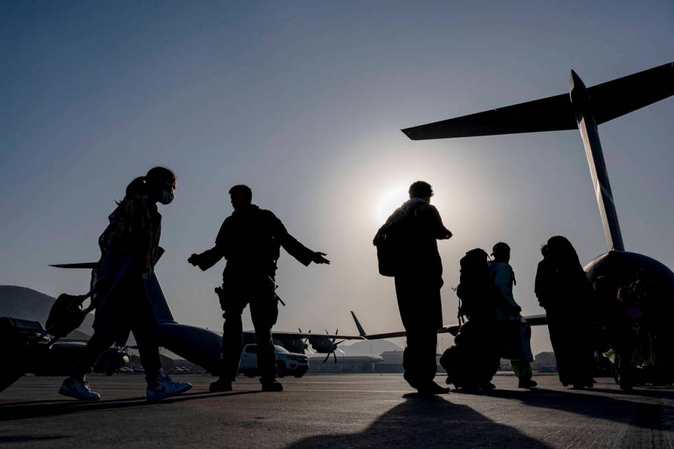 In this image provided by the U.S. Air Force, U.S. Air Force Airmen guides evacuees aboard a U. ...