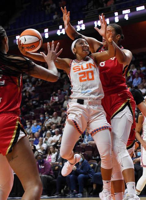 Connecticut Sun's Briann January (20) up for a shot between Las Vegas Aces' Liz Cambage (8) and ...