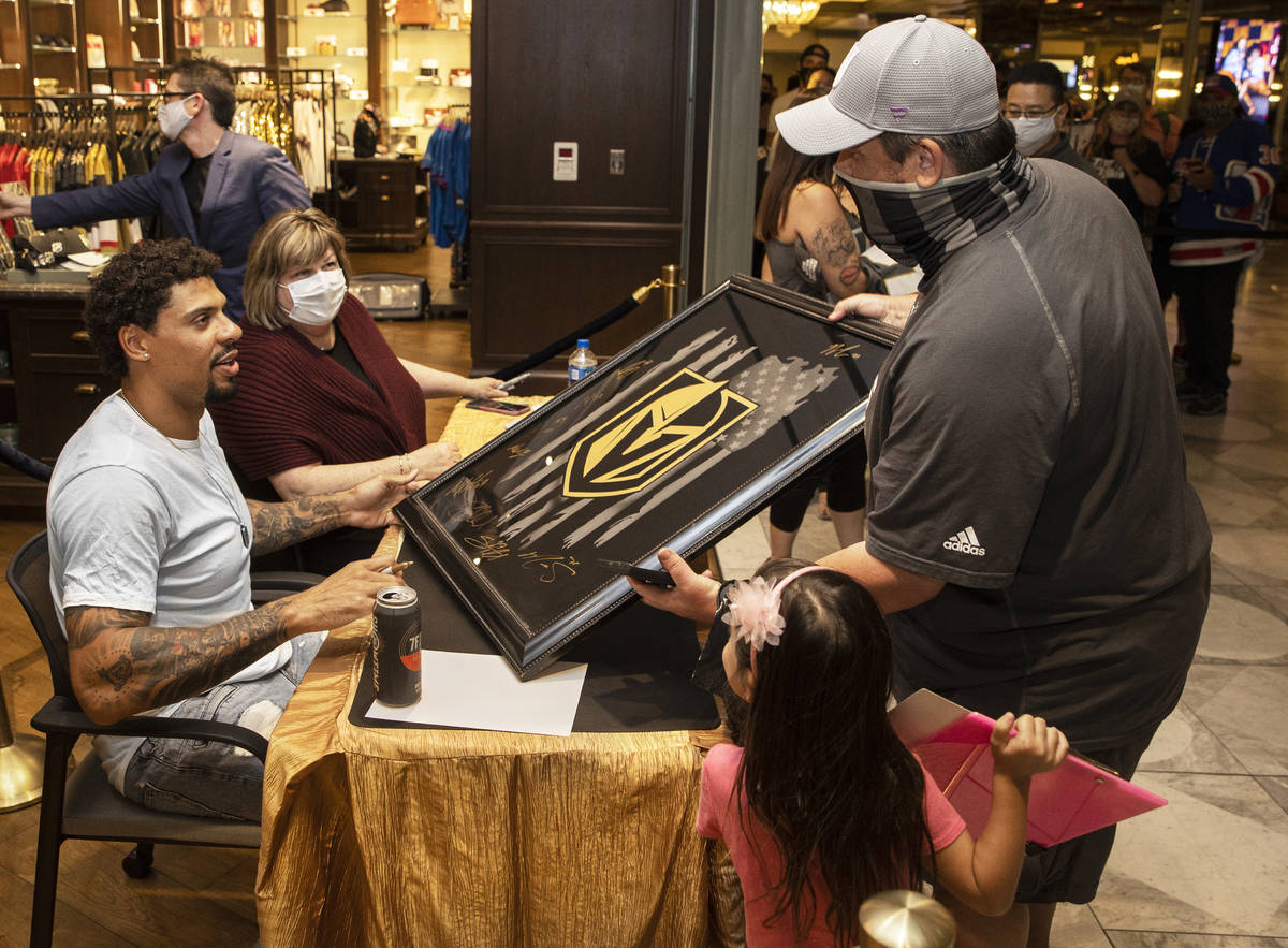 Former Golden Knights player Ryan Reaves, left, signs memorabilia for Mitch Brown during a Send ...