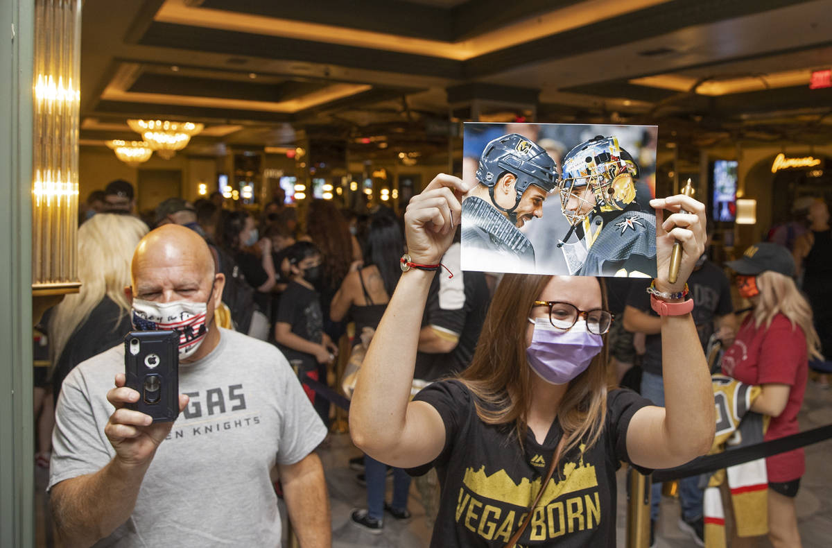 Alex Jones, right, holds a photo of former Golden Knights players Ryan Reaves, top/left, and Ma ...