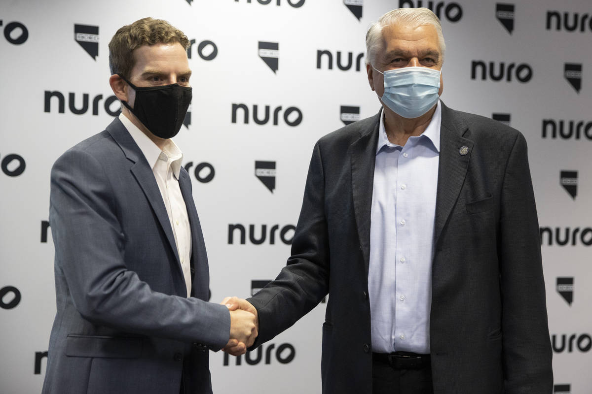 Nuro co-founder and president Dave Ferguson, left, and Gov. Steve Sisolak, shake hands followin ...