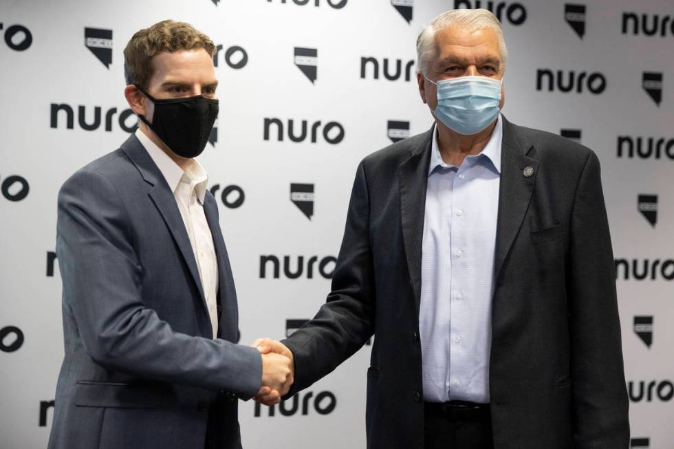 Nuro co-founder and president Dave Ferguson, left, and Gov. Steve Sisolak, shake hands followin ...