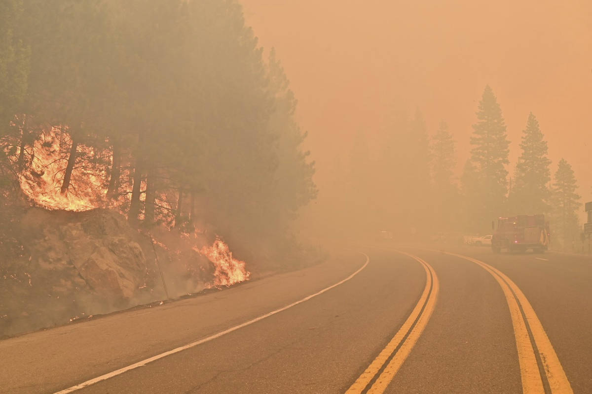 The Caldor Fire burns on both sides of Highway 50 about 10 miles east of Kyburz, Calif., on Thu ...