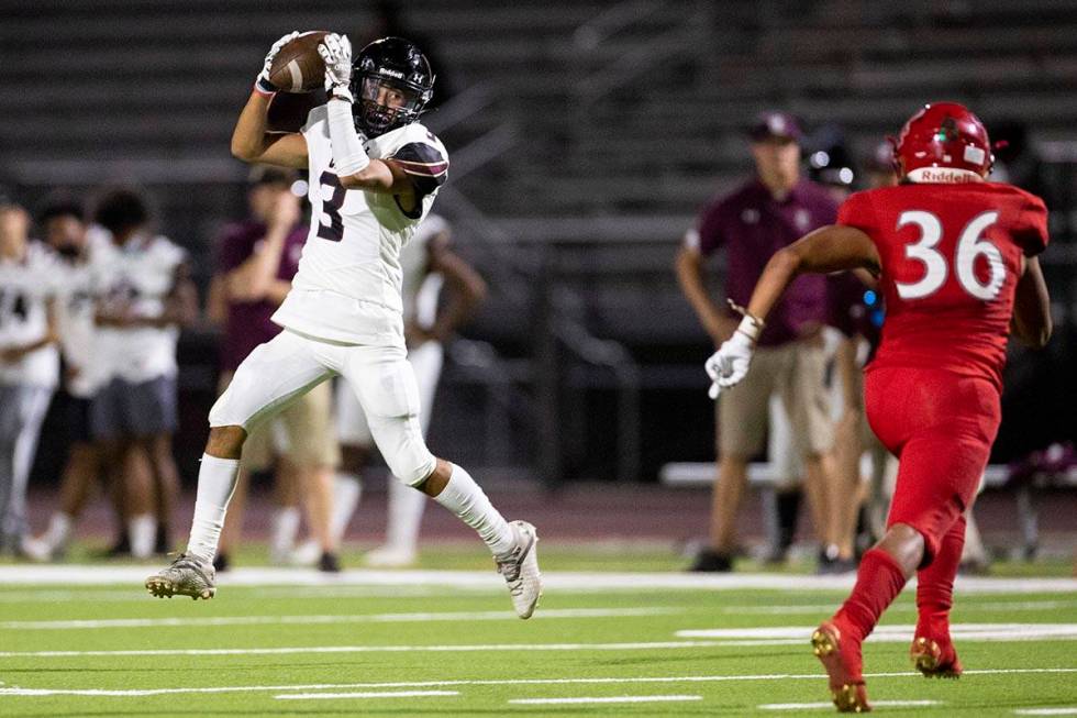 Faith Lutheran's Nicholas Crowell (3) makes a catch as Arbor View's Marcus Young rushes to make ...